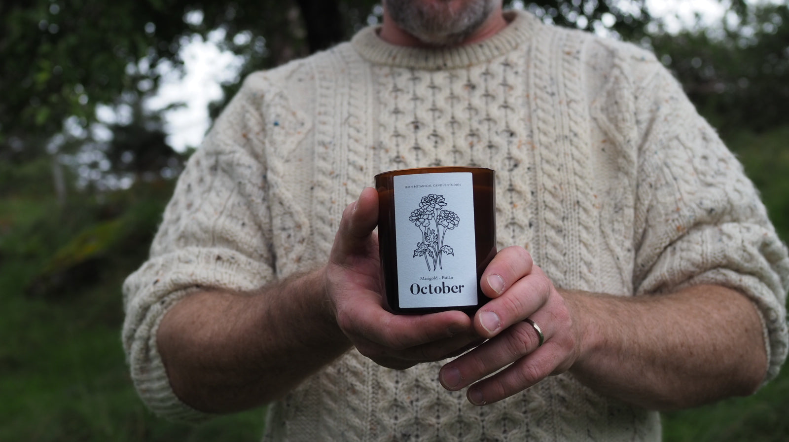 Our founder Michael holding a candle wearing an Irish Arran woollen jumper