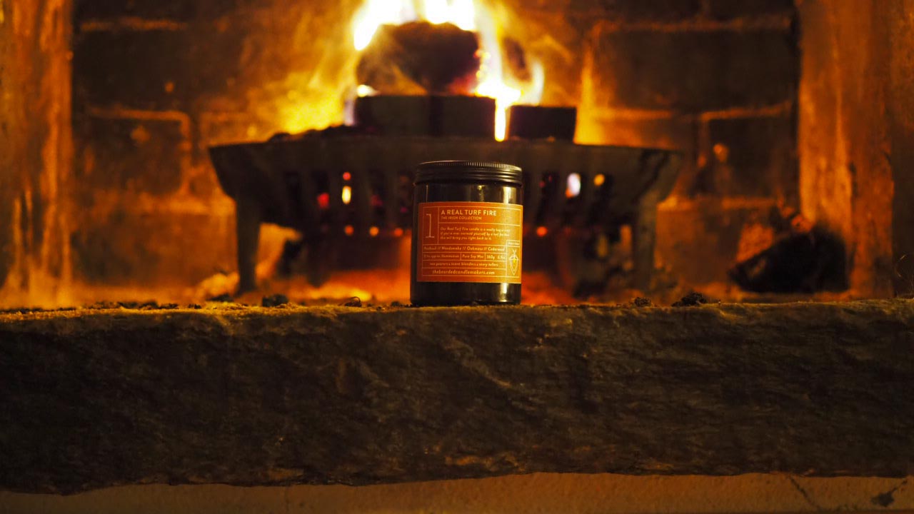a turf fire in a stone heart with a candle in front