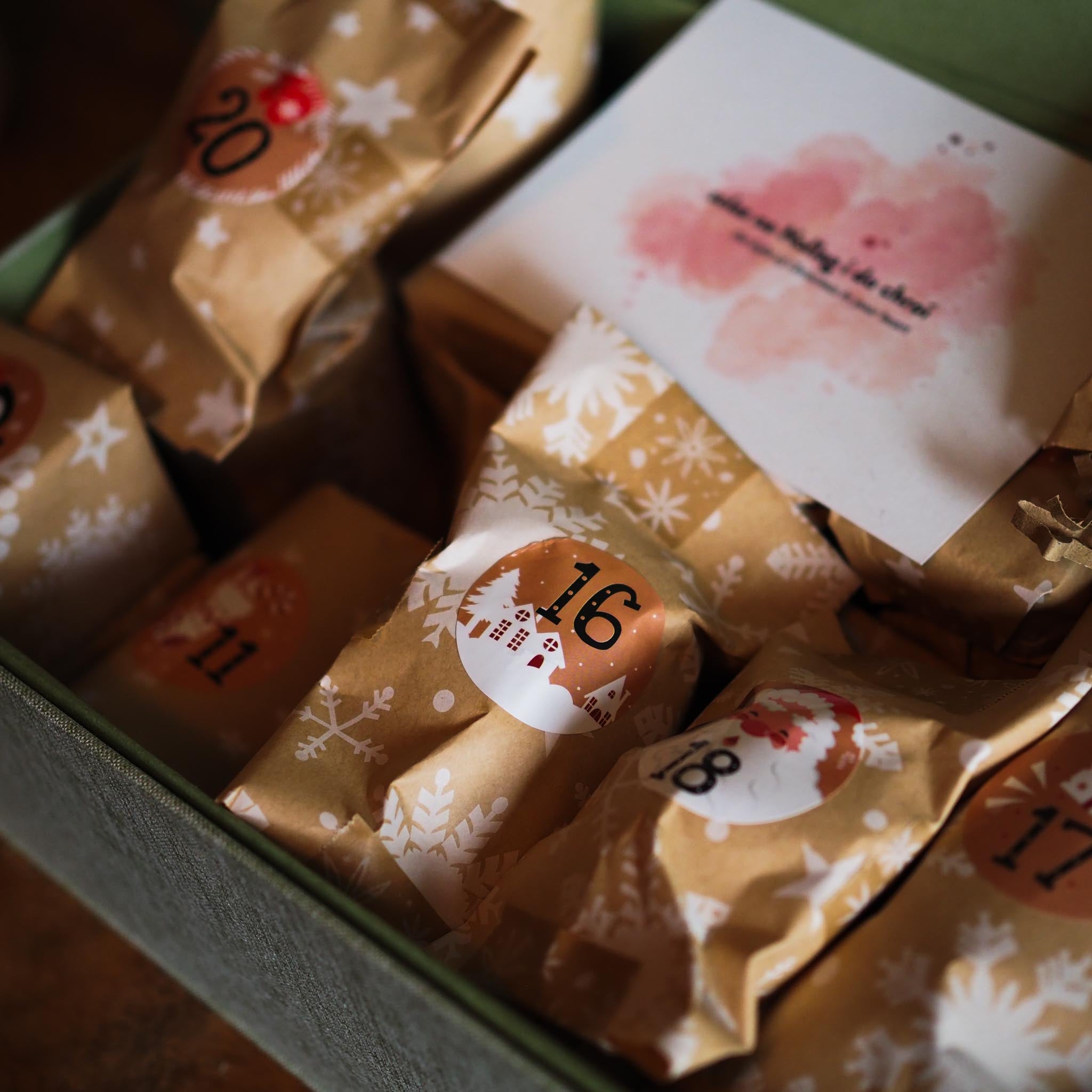 Flat-lay of 24 Days of Christmas advent box showing candles, incense cones and eco friendly wrap