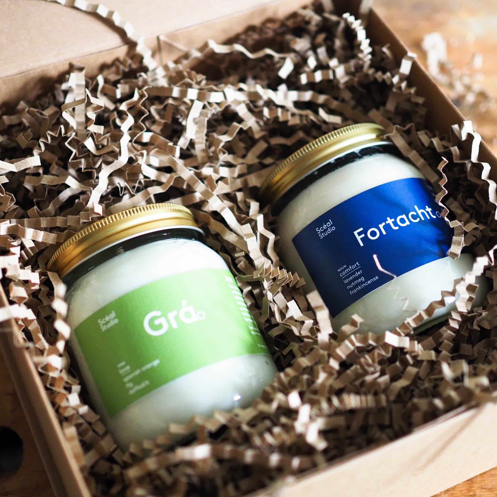 Two large sceal story candles in a gift box